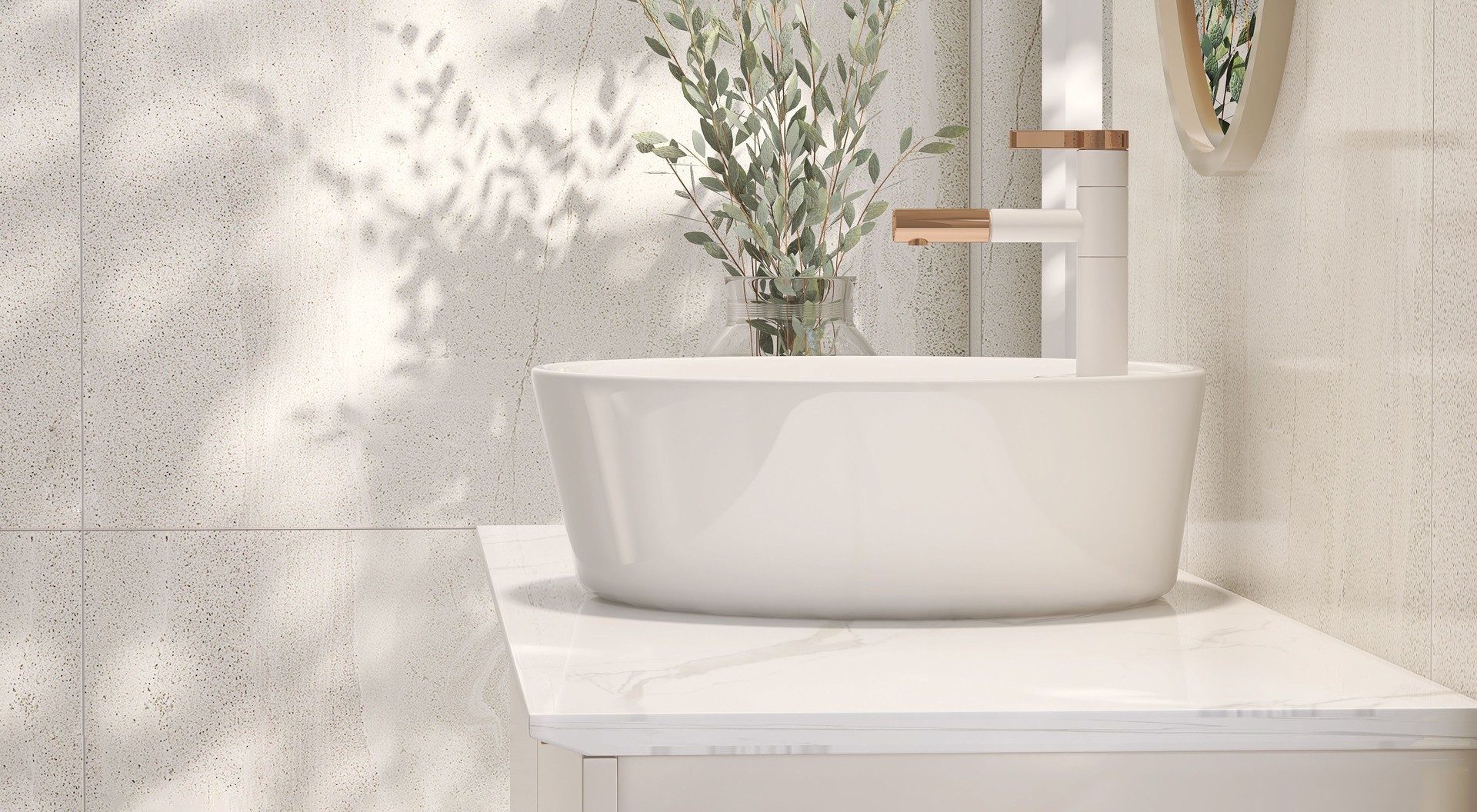 Modern and minimal design of cream colored bathroom vanity with marble counter top and white round ceramic washbasin with vase of houseplant in sunlight from window