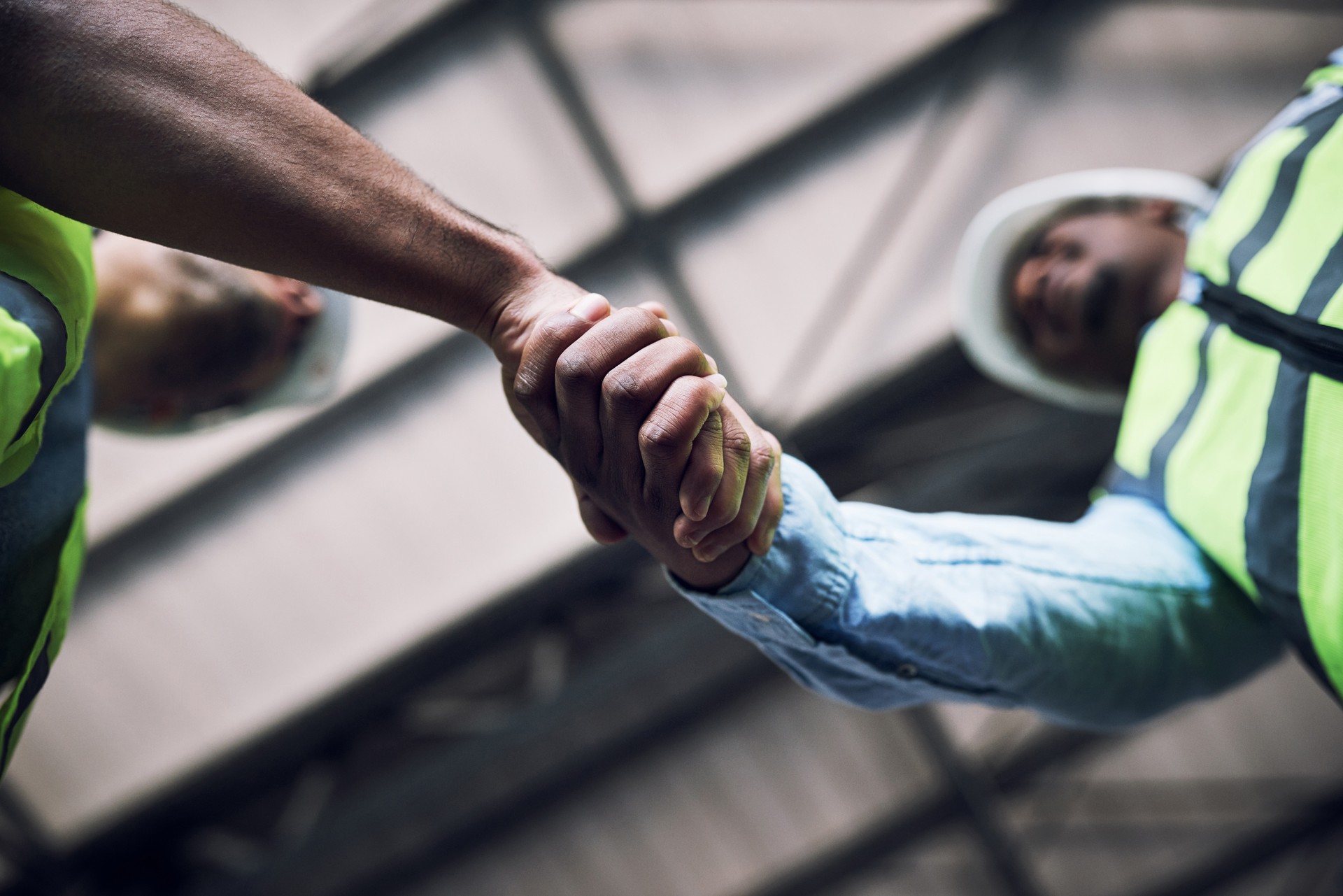 Shot of two builders shaking hands at a construction site