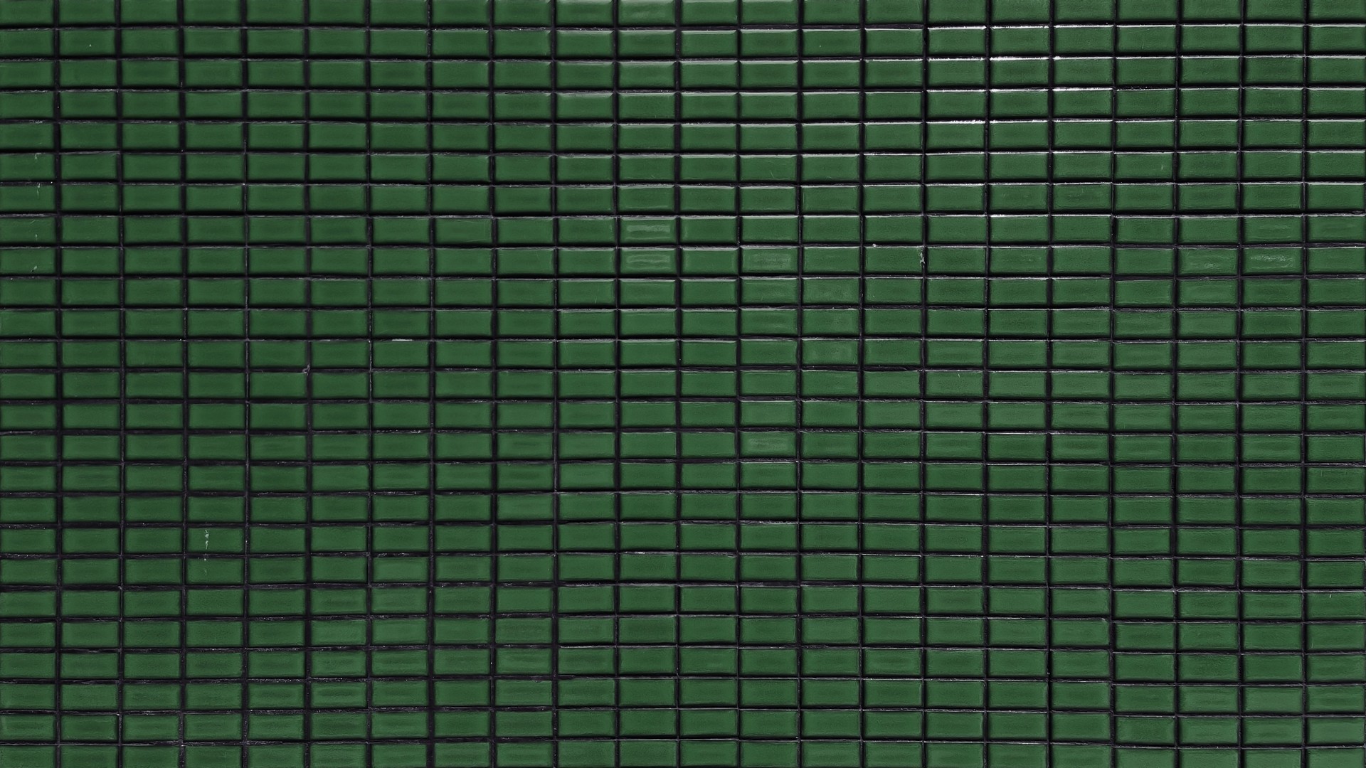 close up dark green colored mosaic wall tiles. ceramic tiles in rectangle pattern, emerald colored. vintage green mosaic kitchen wall pattern used as background.