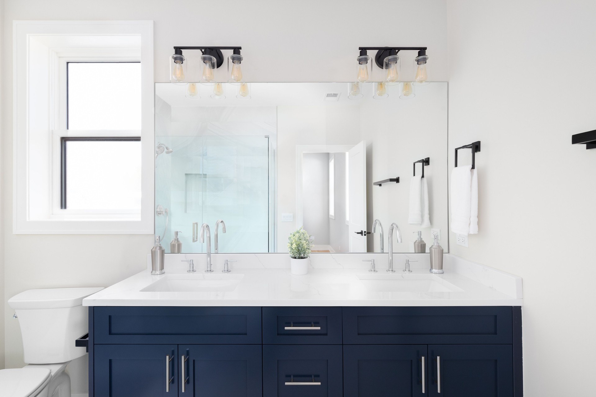 A bathroom with a blue cabinet and white countertop.